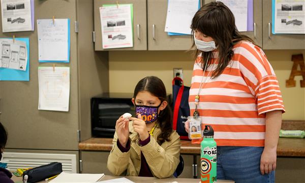 Teacher helps student with food model